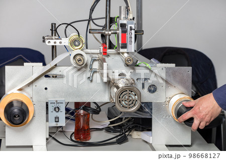 A fitter's hand adjusts a laser print line on self-adhesive drum-wound labels. 98668127