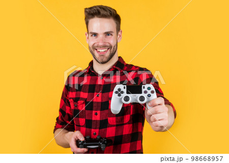 try this one. man playing video game with controller. bearded man using virtual reality gamepad. new videogame online. adult entertainment. video games addicted young guy play with console 98668957