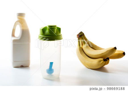 Sports plastic shaker, milk and bananas. Transparent shaker for sports mixtures. Isolated. Sports plastic shaker, milk and bananas. Transparent shaker for sports mixtures. Isolated. 98669188