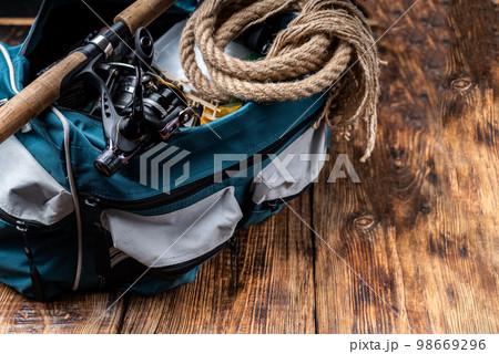 Fishing bag with items for fishing. A fishing rod with a reel and a tackle bag. Fishing composition. 98669296
