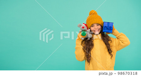 Shopping tips. Rat symbol of year. Happy girl hold mouse toy and wrapped gift box. Kid knitted sweater and hat play plush toy. Shop for kids. Happy 2020 year. Gift for good luck. Appease with gift Shopping tips. Rat symbol of year. Happy girl hold mouse toy and wrapped gift box. Kid knitted sweater and hat play plush toy. Shop for kids. Happy 2020 year. Gift for good luck. Appease with gift 98670318