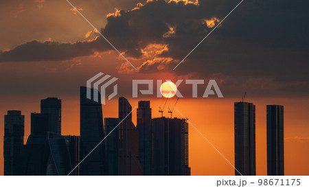The setting sun over the skyscrapers of the Moscow City office center on a summer evening. Sunset. 98671175