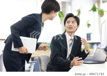 作成中の資料について打ち合わせるビジネスパーソン男女6 98671783