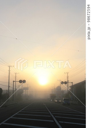 国道沿い霧の朝 朝日の街の風景 98672594
