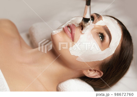 Young beautiful woman with facial mask, spa treatment Young beautiful woman with facial mask, spa treatment 98672760