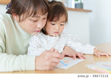 お絵描きをして遊ぶ女の子とお母さん 98673318
