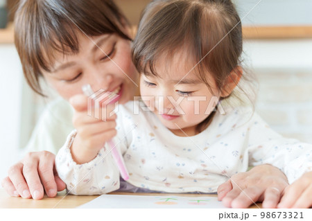 お絵描きをして遊ぶ女の子とお母さん 98673321