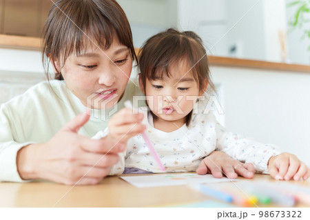 お絵描きをして遊ぶ女の子とお母さん 98673322