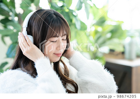 ヘッドホンで音楽を聴く若い女性 ヘッドホンで音楽を聴く若い女性 98674205
