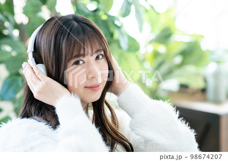 ヘッドホンで音楽を聴く若い女性 ヘッドホンで音楽を聴く若い女性 98674207