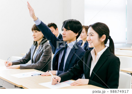 オフィス・会議室で挙手して積極的に質問・意見・発言するビジネスマン・会社員の男女（セミナー） 98674917