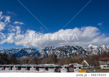 ゲレンデから眺める美しい雪山の眺望とスキーバスの列 ゲレンデから眺める美しい雪山の眺望とスキーバスの列 98676930