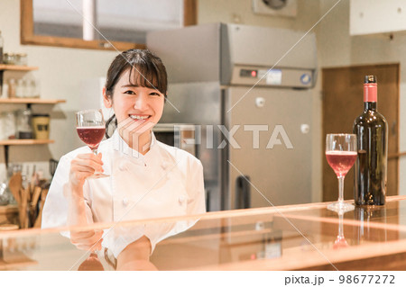 飲食店・バー・居酒屋・ワインバー・バル・ワインショップで赤ワインを持つ女性(ソムリエ・シェフ) 飲食店・バー・居酒屋・ワインバー・バル・ワインショップで赤ワインを持つ女性(ソムリエ・シェフ) 98677272