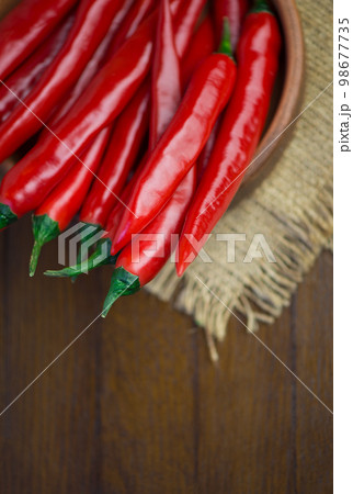 spicy food. Top view red dried crushed hot chili and raw chili in wooden bowl on rustic background, healthy spice 98677735