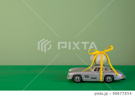 Easter egg on a gray car on a green background. Copy space. Easter egg on a gray car on a green background. Copy space. 98677854