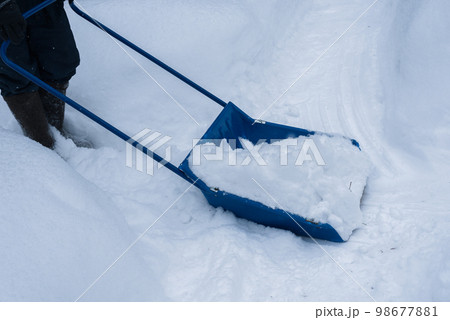 Man cleaning snow with shovel in winter day. Man cleaning snow with shovel in winter day. 98677881