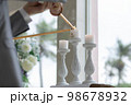 結婚式でキャンドルに火をともす 98678932
