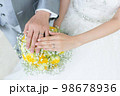 新郎新婦の手と黄色いブーケ 98678936