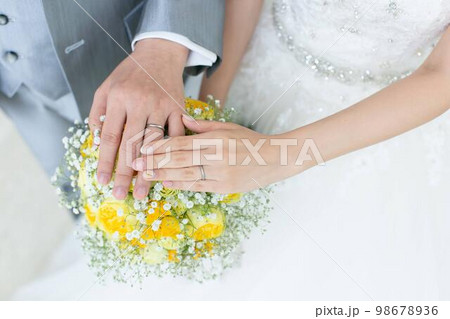 新郎新婦の手と黄色いブーケ 98678936