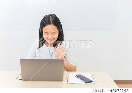 パソコンでテレビ電話・ビデオ通話する小学生・中学生の子供（女の子） 98679248