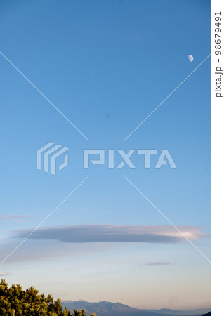 冬に枯れた高山植物と満月と笠雲 98679491