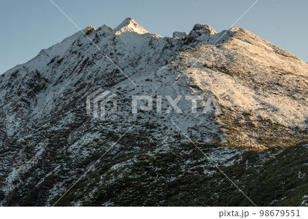 晴天の下で長野と岐阜の県境の西穂高岳稜線から見るアルプスの稜線 北アルプスの山々 晴天の下で長野と岐阜の県境の西穂高岳稜線から見るアルプスの稜線 北アルプスの山々 98679551
