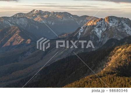 11月の早朝に晴天の下で西穂高岳の稜線で見る日の出　厳冬期の自然　朝焼けに染まる北アルプスの山々 98680346