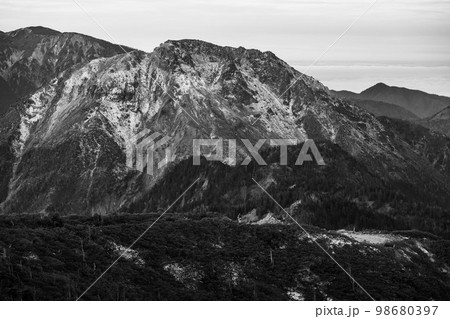 曇天の下で長野と岐阜の県境の西穂高岳稜線から見るアルプスの稜線　雲流れる北アルプスの山々 98680397