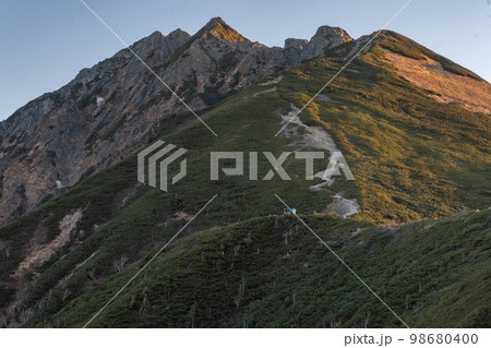 曇天の下で長野と岐阜の県境の西穂高岳稜線から見るアルプスの稜線 雲流れる北アルプスの山々 曇天の下で長野と岐阜の県境の西穂高岳稜線から見るアルプスの稜線 雲流れる北アルプスの山々 98680400