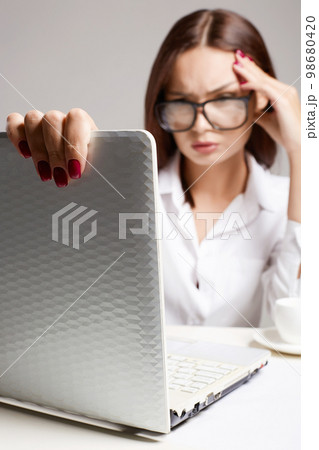 Young business woman in office. Beautiful girl in glasses Young business woman in office. Beautiful girl in glasses 98680420