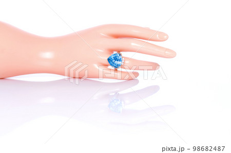 Swiss Blue Topaz concave cut and diamond ring on plastic mannequin female hand. Collection of natural gemstones accessories. Studio shot 98682487