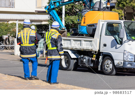 道路の補修工事の開始を待つ交通誘導員 98683517