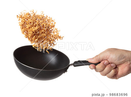 Instant Noodle fly in iron pan, yellow instant noodle float explode, abstract cloud fly. Curved dried instant noodles splash throwing in Air. White background Isolated high speed shutter, freeze 98683696