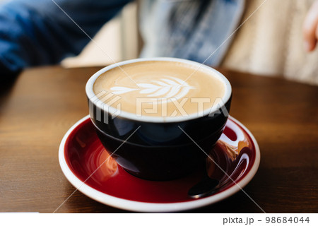 Cappuccino mug close up decorated on top of foam 98684044