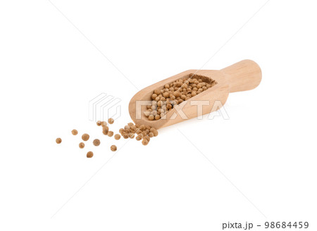 coriander seeds in  wooden scoop on white background. 98684459