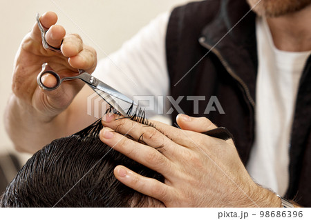 hairdresser does haircut for caucasian bearded man 98686396
