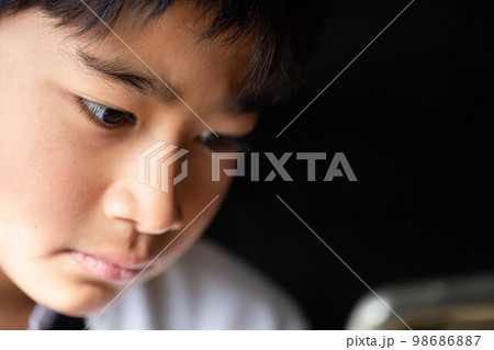 端末を見る子供 98686887