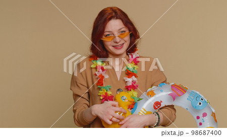 Traveler tourist young redhead woman celebrating, dancing fooling with swimming inflatable duck toy Traveler tourist young redhead woman celebrating, dancing fooling with swimming inflatable duck toy 98687400