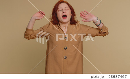 Tired sleepy redhead woman yawning, feeling somnolent lazy bored gaping suffering from lack of sleep 98687467