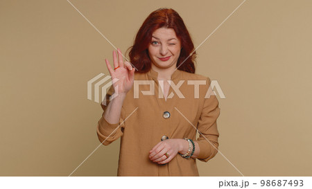 Woman looking approvingly, showing ok approve feedback gesture like sign positive something good Woman looking approvingly, showing ok approve feedback gesture like sign positive something good 98687493