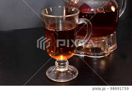 Tea in a tall glass and teapot Tea in a tall glass and teapot 98691739