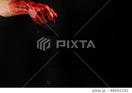 Faceless man holding handcuffs black background. Hands are stained with blood. Faceless man holding handcuffs black background. Hands are stained with blood. 98692291