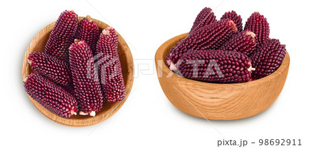 Purple corn in wooden bowl isolated on white background with full depth of field. Top view. Flat lay. Purple corn in wooden bowl isolated on white background with full depth of field. Top view. Flat lay. 98692911