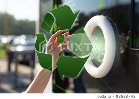 Woman uses a self service machine to receive used plastic bottles 98693745
