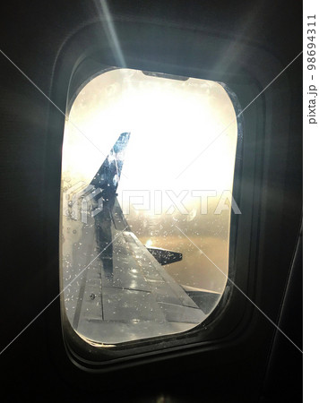 Beautiful view from airplane window, large wing of aircraft shows casement Beautiful view from airplane window, large wing of aircraft shows casement 98694311