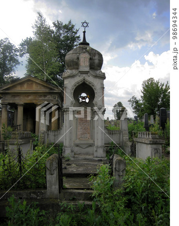 Old abandoned Jewish cemetery with stone graves between trees 98694344