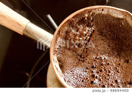 Barista preparing hot tasty drink from copper turk 98694400
