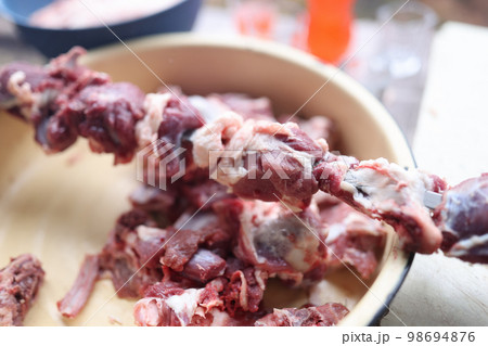 Preparing raw meat for barbecue close-up. 98694876