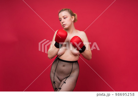Seductive confident female boxer with gloves studio, sporty woman posing looking at camera. 98695258