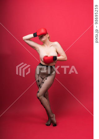 Seductive confident female boxer with gloves studio, sporty woman posing looking at camera. 98695259